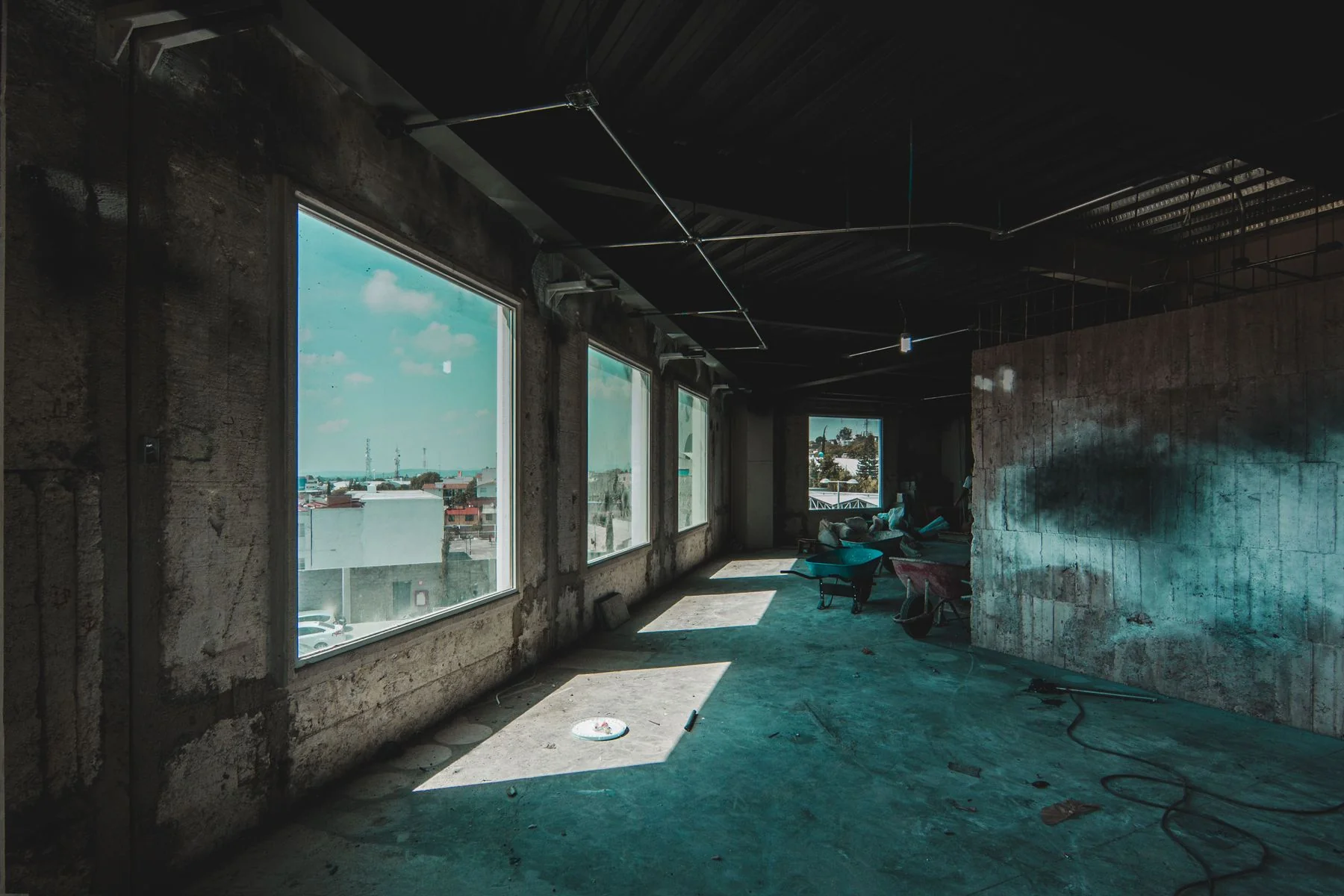 Interior undergoing renovation with large window openings