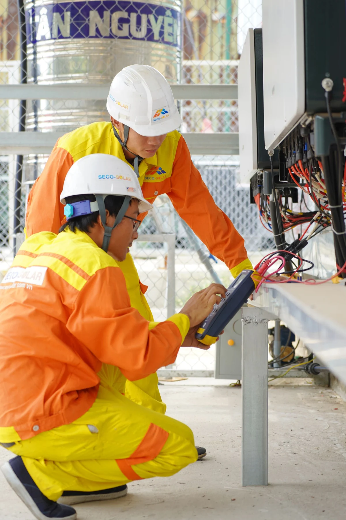 Two technicians inspecting industrial electrical wiring