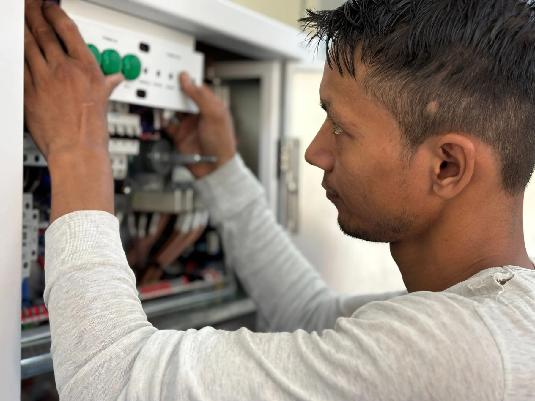 Technician adjusting an electrical control panel