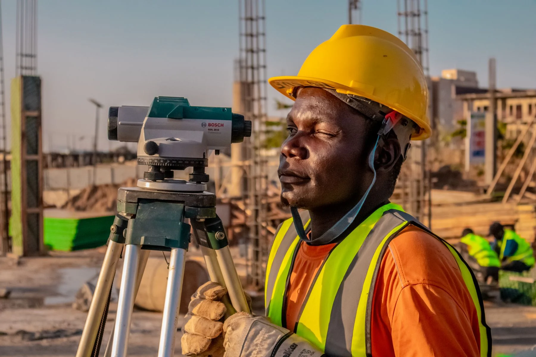 Worker using a surveying instrument on a construction site