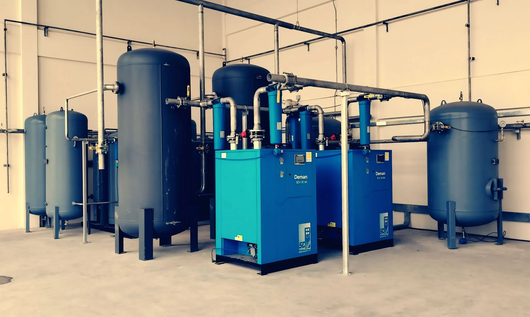 Industrial air compressor connected to pipework in a plant