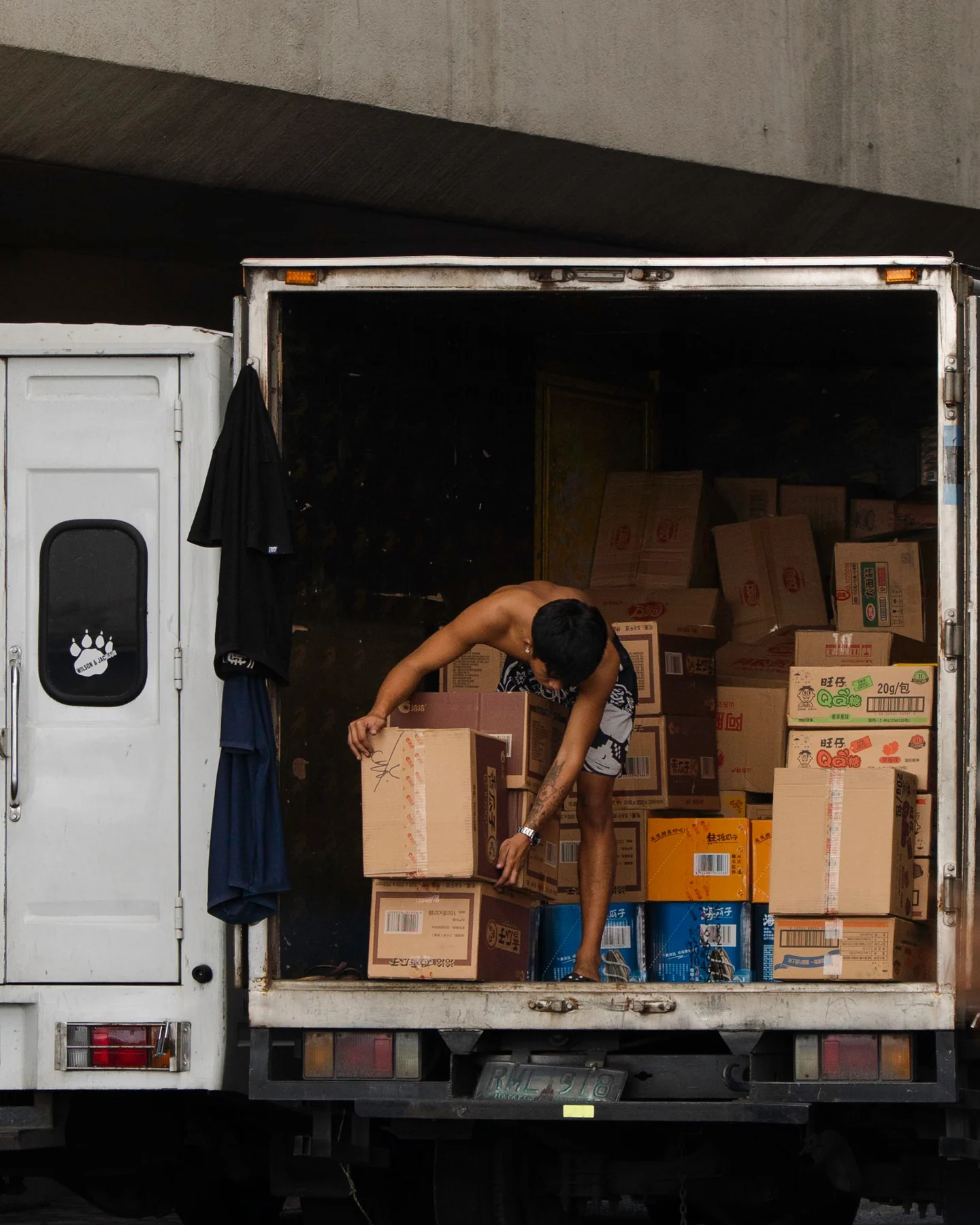 Worker organizing boxed cargo inside a delivery truck