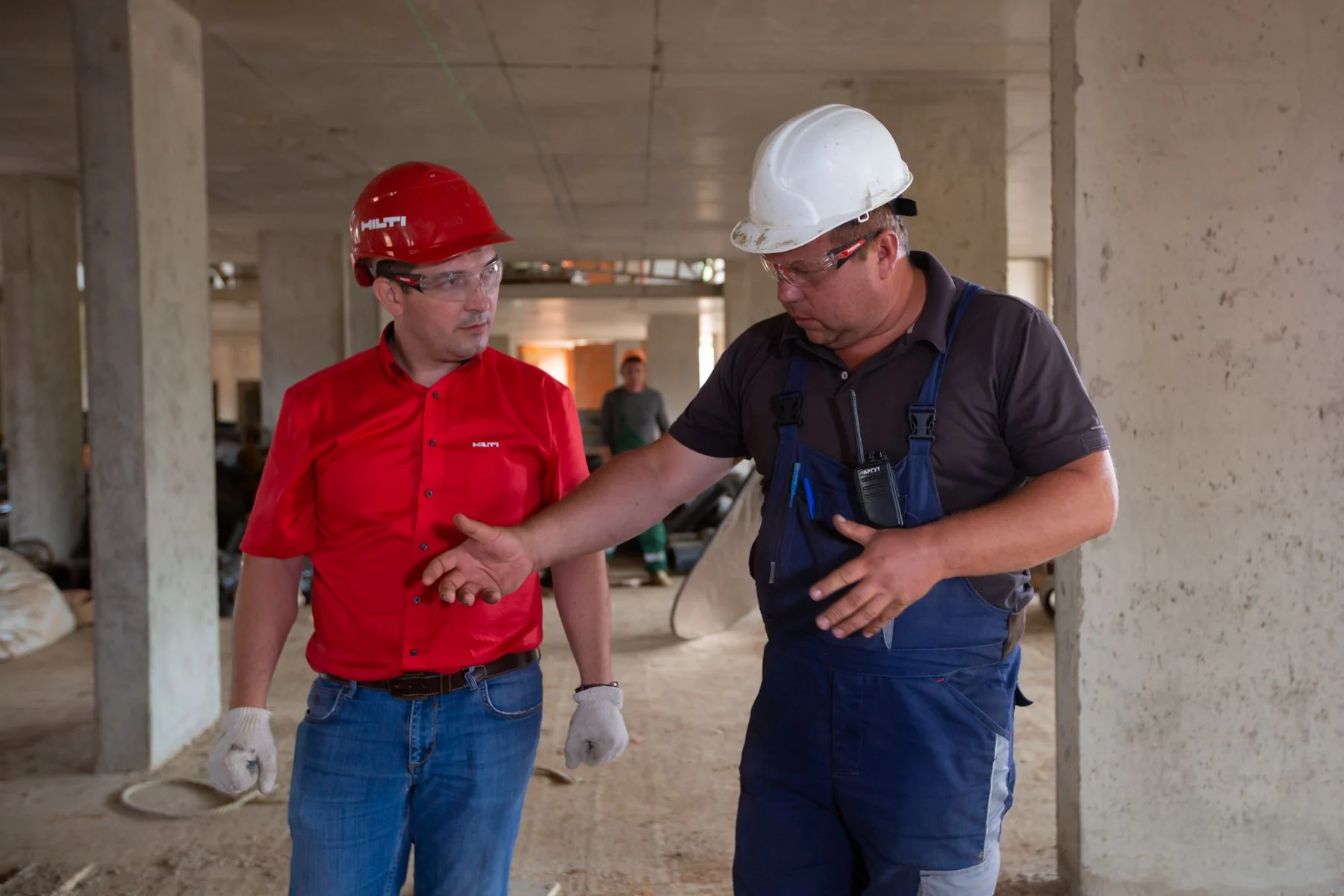 Two workers discussing requirements inside an unfinished building