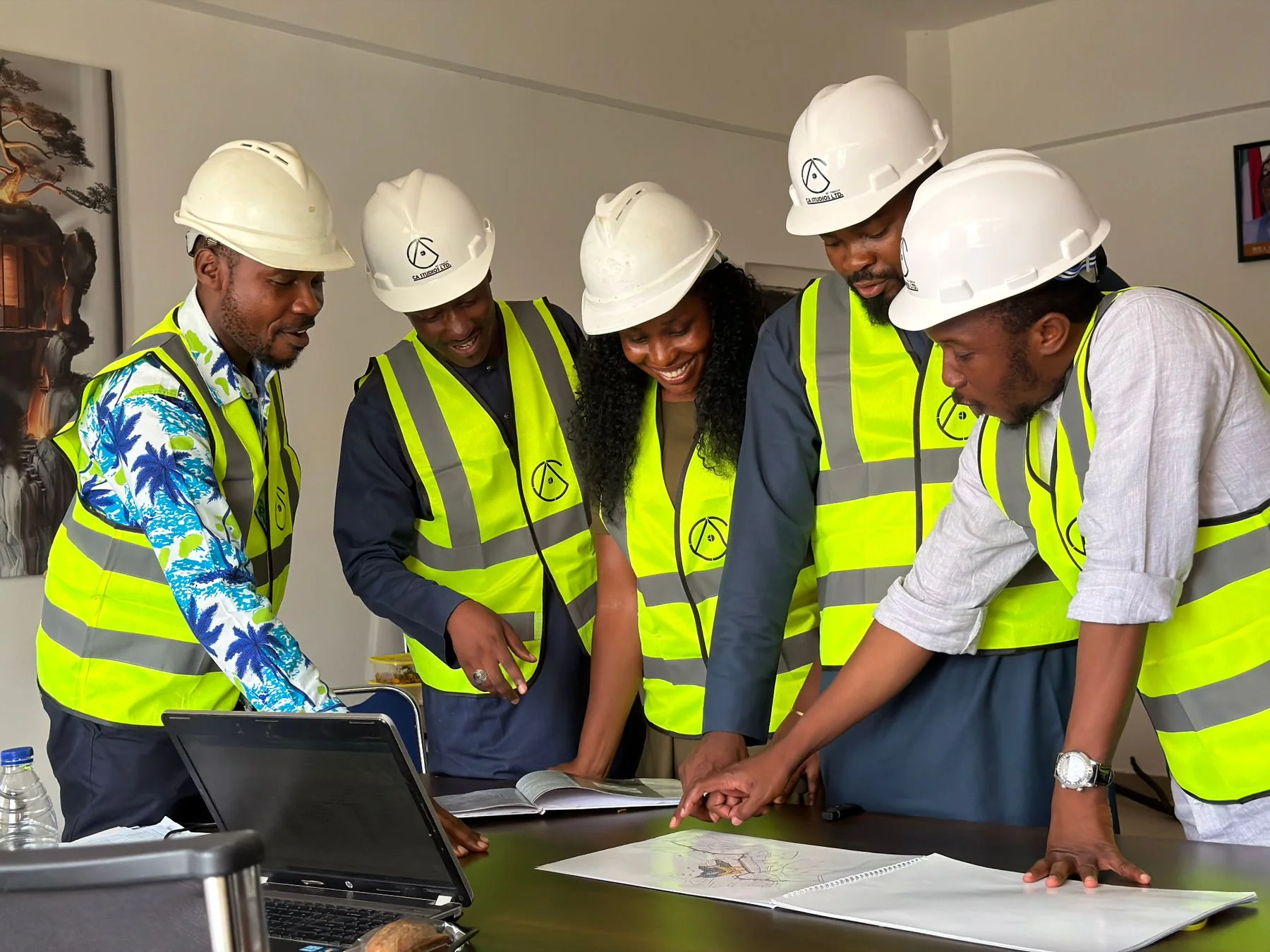Group reviewing drawings at a table with a laptop