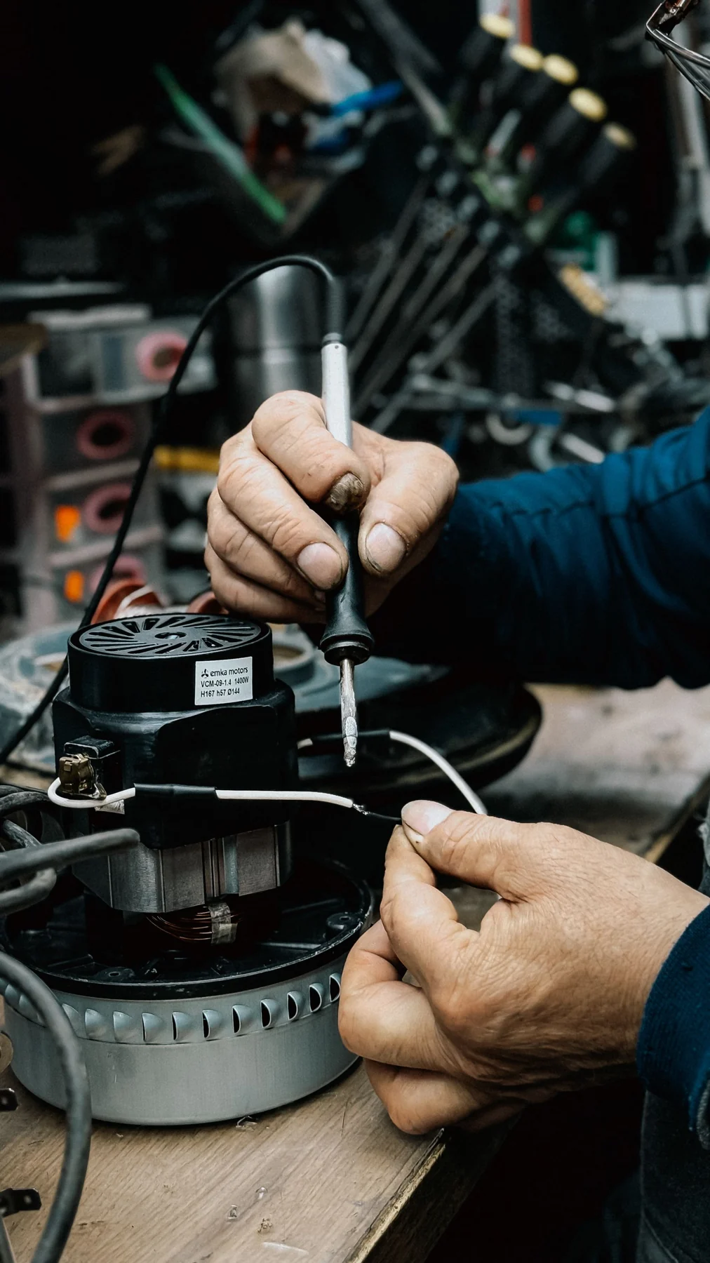 Hands using a screwdriver on a motor and equipment components