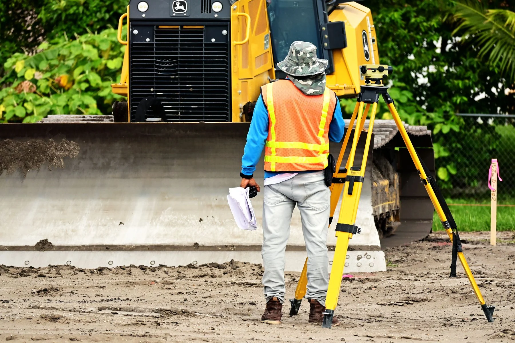 Surveyor and measuring equipment beside a work area