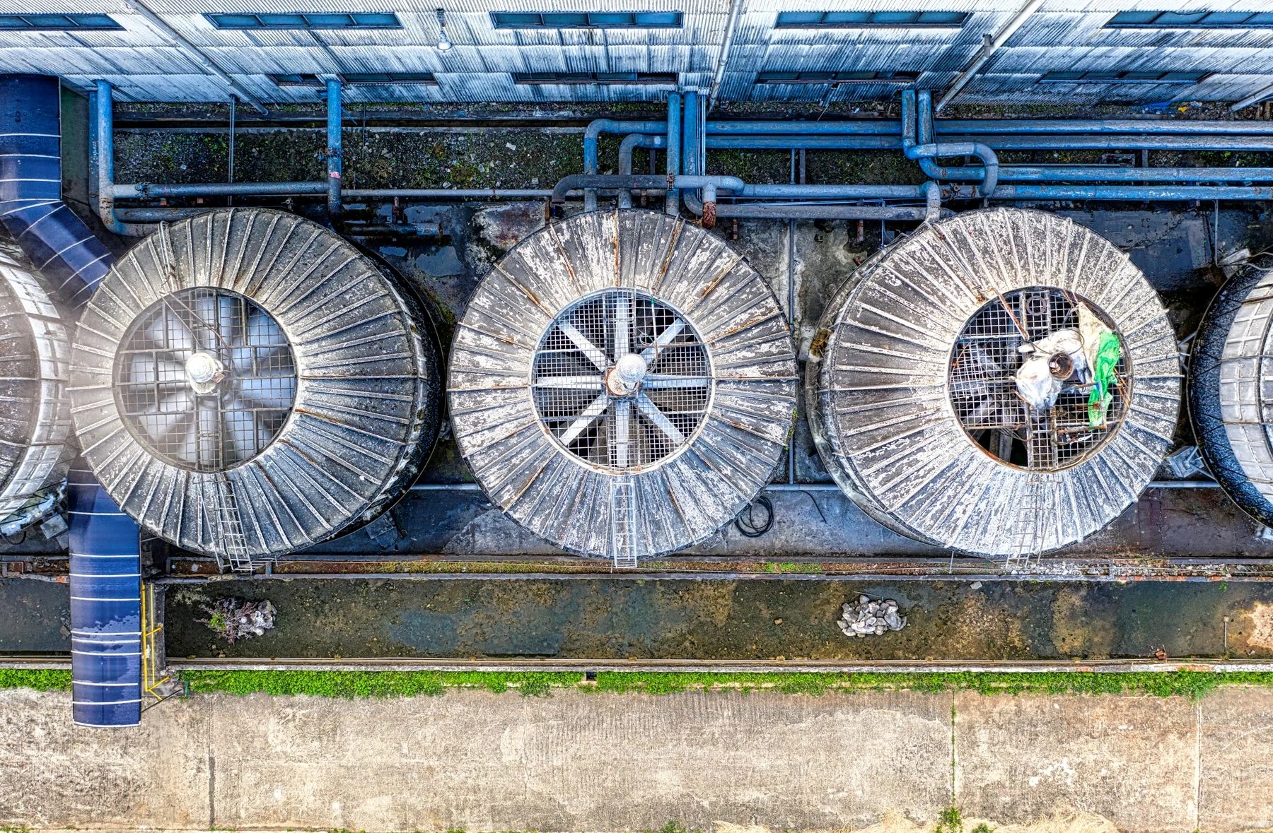 Overhead view of industrial cooling tower fans and pipework
