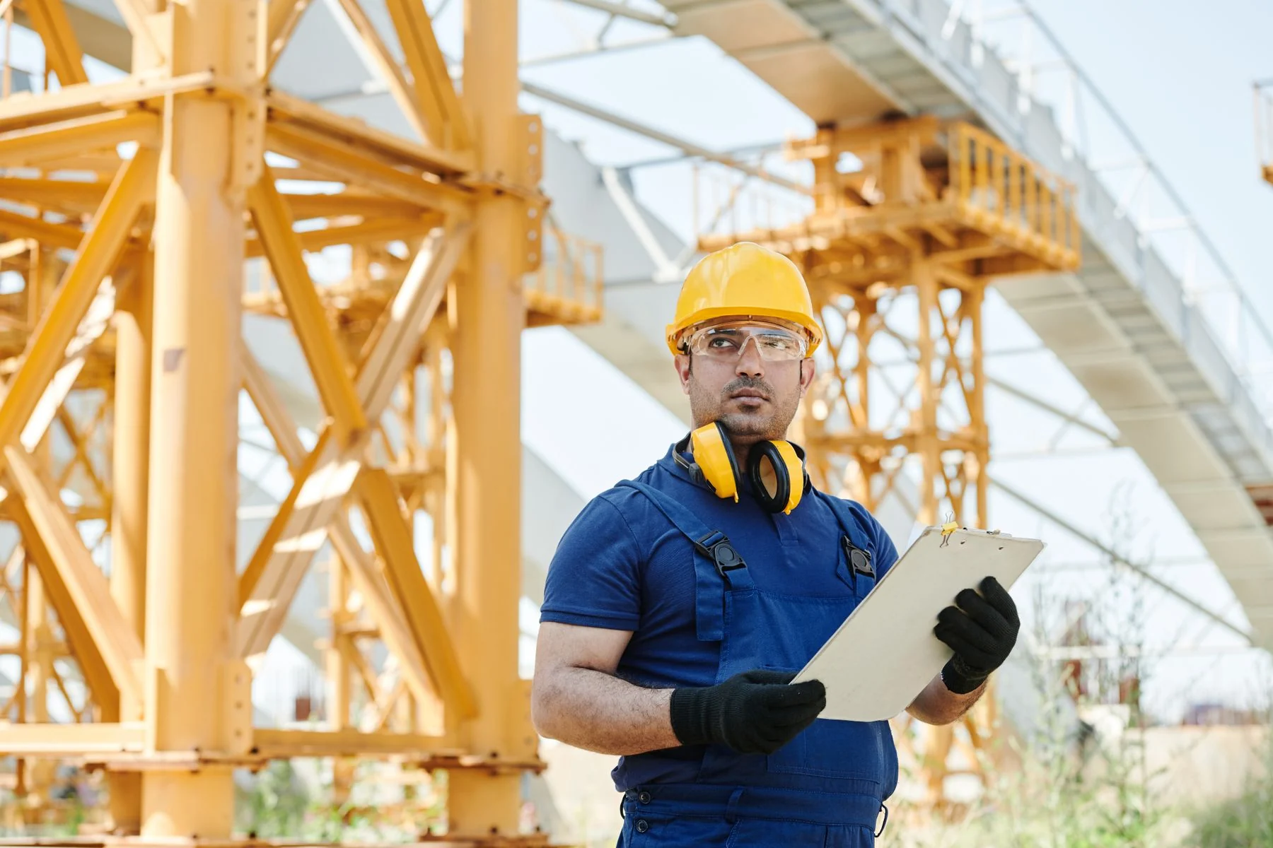 Worker holding a clipboard at an outdoor construction site