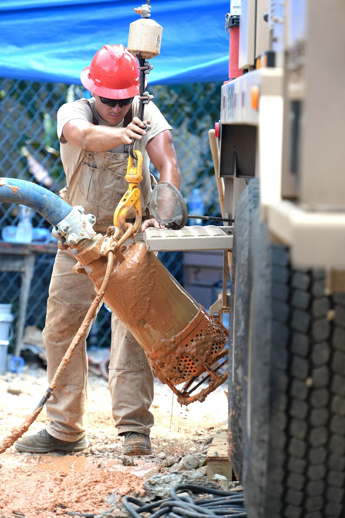 Worker positioning a submersible pump on a work site