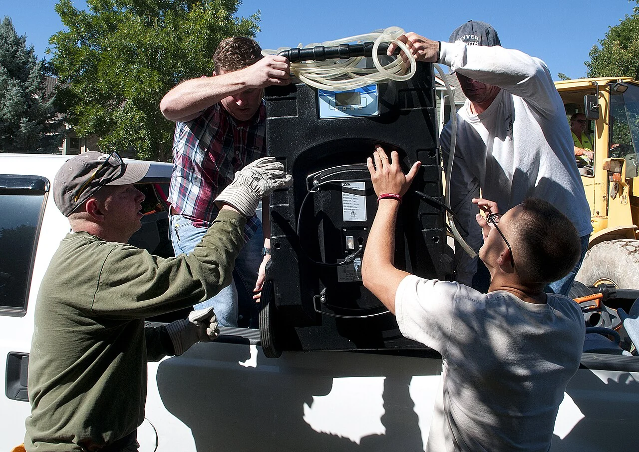 People handling a dehumidifier during a flood recovery activity