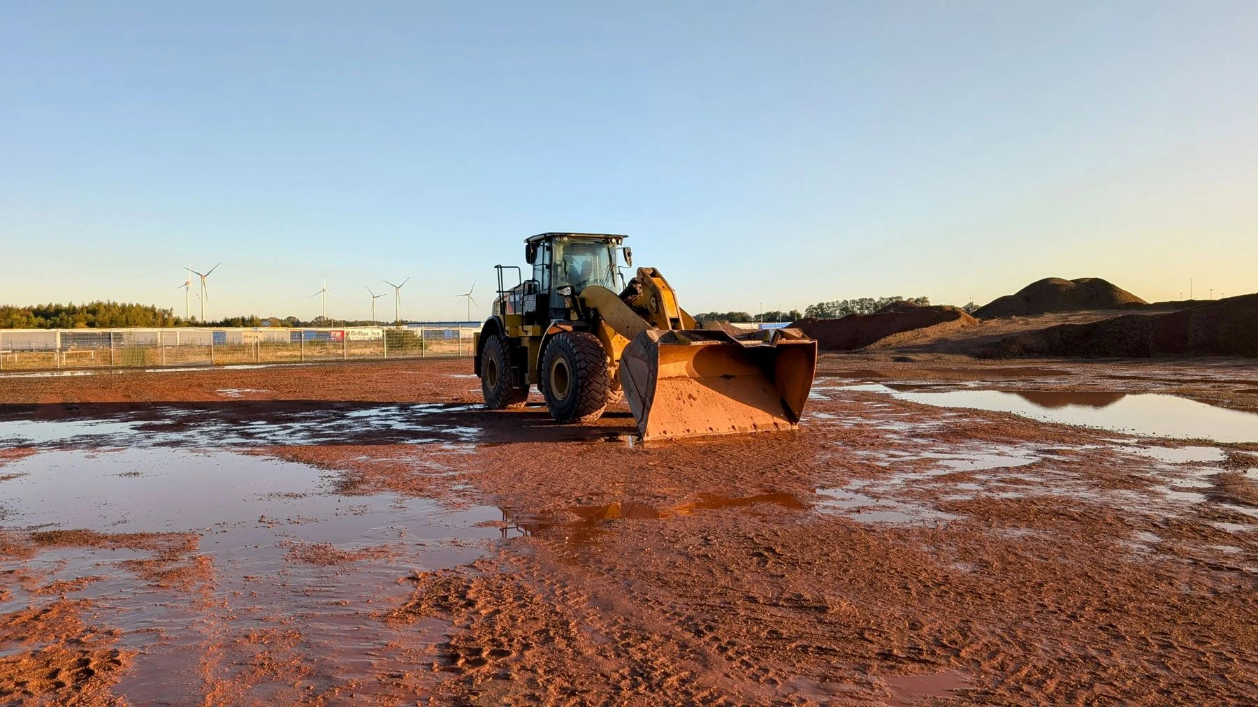 Standing water and muddy ground around a loader at a construction site