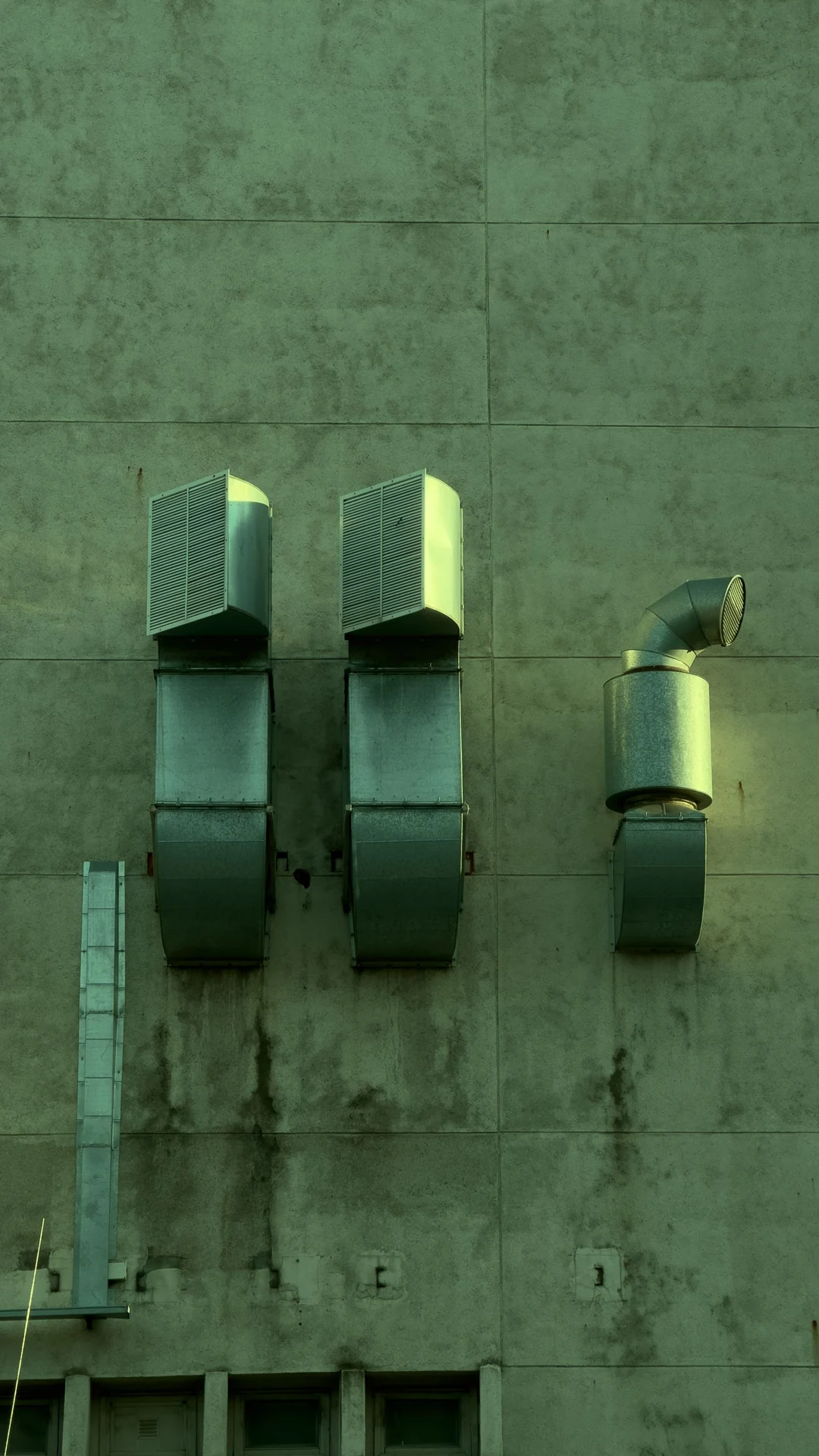 Exterior ventilation ducts and fan housings on a building