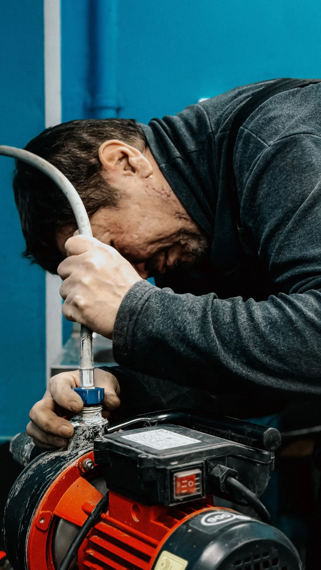 Technician adjusting the pipe connection on an electric water pump