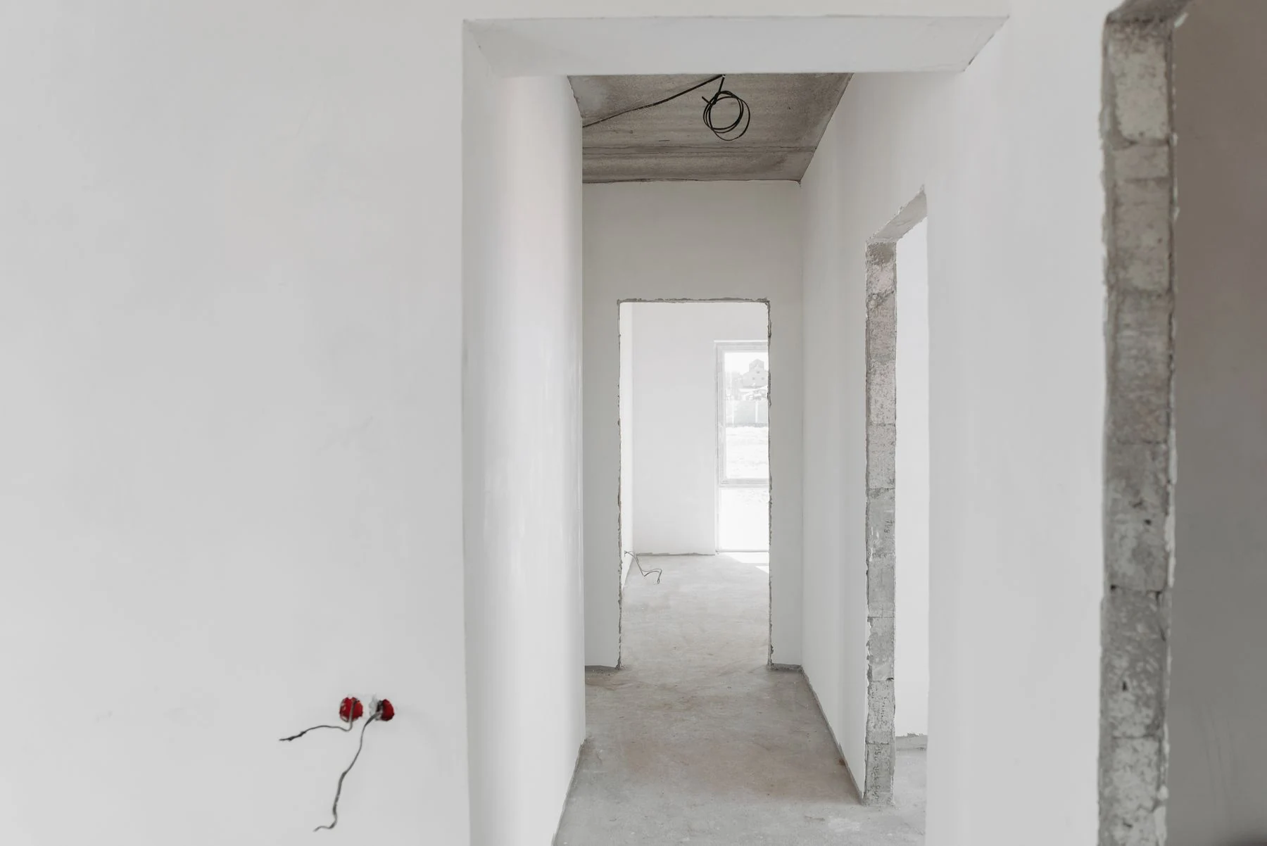 Unfinished interior with plastered walls and door openings
